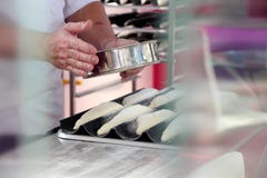 Piekarz ręki kropią wypiekową mąkę, przed robić mu w piekarniku obraz stock Piekarz ręki kropią wypiekową mąkę, przed robić mu w piekarniku obraz stock