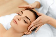 Piel, cuidado del cuerpo Mujer que consigue masaje de cara del balneario de la belleza Treatmen imagen de archivo Piel, cuidado del cuerpo Mujer que consigue masaje de cara del balneario de la belleza Treatmen imagen de archivo