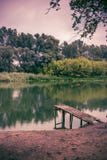 Pier auf einem ruhigen Fluss im Sommer Hölzerne Pierbrücke lizenzfreies stockbild Pier auf einem ruhigen Fluss im Sommer Hölzerne Pierbrücke lizenzfreies stockbild