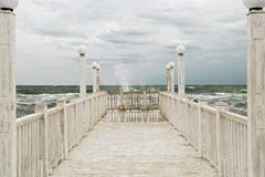 Pier with white wooden handrails at sea during a storm. Stock Images Pier with white wooden handrails at sea during a storm. Stock Images
