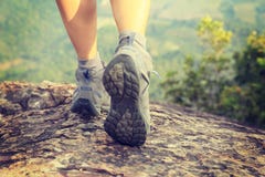 Piernas del caminante de la mujer joven que suben en el pico de montaña imagen de archivo libre de regalías Piernas del caminante de la mujer joven que suben en el pico de montaña imagen de archivo libre de regalías