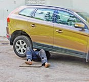 Piernas del mecánico que repara el coche Foto de archivo libre de regalías Piernas del mecánico que repara el coche Foto de archivo libre de regalías