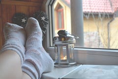 Piernas en calcetines Mujer que se relaja en casa cerca de la ventana Decoración en la sala de estar imagen de archivo Piernas en calcetines Mujer que se relaja en casa cerca de la ventana Decoración en la sala de estar imagen de archivo