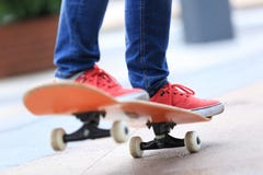 Piernas jovenes del skater que montan en el monopatín fotos de archivo libres de regalías Piernas jovenes del skater que montan en el monopatín fotos de archivo libres de regalías