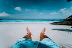 Piernas masculinas del fondo de las vacaciones del viaje con cortocircuito de la nadada en la playa tropical de la arena blanca d foto de archivo libre de regalías Piernas masculinas del fondo de las vacaciones del viaje con cortocircuito de la nadada en la playa tropical de la arena blanca d foto de archivo libre de regalías