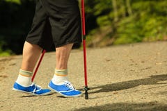 Piernas mayores activas en nordic de las zapatillas de deporte que camina en un parque Foto de archivo libre de regalías Piernas mayores activas en nordic de las zapatillas de deporte que camina en un parque Foto de archivo libre de regalías