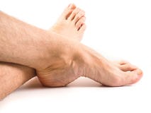 Piernas melenudas y pies de la persona masculina que descansan un blanco imágenes de archivo libres de regalías Piernas melenudas y pies de la persona masculina que descansan un blanco imágenes de archivo libres de regalías