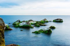 Pietre coperte di muschio in un mare un giorno di estate, vista sul mare fotografia stock libera da diritti Pietre coperte di muschio in un mare un giorno di estate, vista sul mare fotografia stock libera da diritti