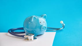 Piggy bank with stethoscope  on blue background. concept of financial literacy. Creating and maintaining a