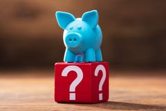 Piggybank auf rotem Block mit Fragezeichen stockfoto Piggybank auf rotem Block mit Fragezeichen stockfoto