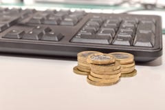 Pila de monedas de libra con un teclado fotos de archivo Pila de monedas de libra con un teclado fotos de archivo