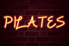 Pilates neon sign on brick wall background. Fluorescent Neon tube Sign on brickwork Business concept for Fitness Balance Workout E stock photography Pilates neon sign on brick wall background. Fluorescent Neon tube Sign on brickwork Business concept for Fitness Balance Workout E stock photography