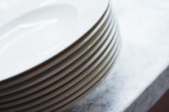 Pile de plats propres sur la table Nettoyez les plats préparés sur une table blanche dans la cuisine Photo libre de droits Pile de plats propres sur la table Nettoyez les plats préparés sur une table blanche dans la cuisine Photo libre de droits