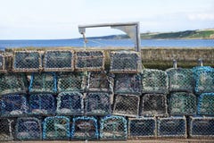 Pile de pots de filet de homard au port par le mur en pierre pour que le pêcheur attrape le poisson de mer et la nourriture photo stock Pile de pots de filet de homard au port par le mur en pierre pour que le pêcheur attrape le poisson de mer et la nourriture photo stock