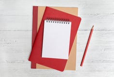 Pile des carnets et d'un crayon rouge sur un fond en bois blanc Configuration plate avec l'espace de copie photos stock Pile des carnets et d'un crayon rouge sur un fond en bois blanc Configuration plate avec l'espace de copie photos stock