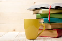 Pile des livres colorés, du livre ouvert et de la tasse sur la table en bois De nouveau à l'école Copiez l'espace image libre de droits Pile des livres colorés, du livre ouvert et de la tasse sur la table en bois De nouveau à l'école Copiez l'espace image libre de droits
