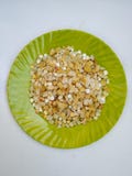 Pile of a Pongal Traditional Raw Mixtures of Ellu Bella in a Green Plate  on white Background