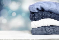 Pile knitted winter autumn clothes on wooden background. royalty free stock images Pile knitted winter autumn clothes on wooden background. royalty free stock images