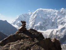 Pile équilibrée de pierres contre le lac brouillé de higland de fond et les montagnes neigeuses photographie stock libre de droits Pile équilibrée de pierres contre le lac brouillé de higland de fond et les montagnes neigeuses photographie stock libre de droits