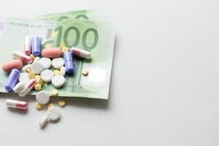Pills on euro money isolated on white background. Medicine expenses. Place for text royalty free stock image Pills on euro money isolated on white background. Medicine expenses. Place for text royalty free stock image