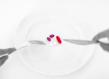 Pills on a plate with fork and knife. Diet concept. stock photography Pills on a plate with fork and knife. Diet concept. stock photography
