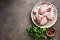 Pilon de poulet cru avec les épices et le persil sur un fond rustique foncé Vue sup?rieure, l'espace de copie photos stock Pilon de poulet cru avec les épices et le persil sur un fond rustique foncé Vue sup?rieure, l'espace de copie photos stock