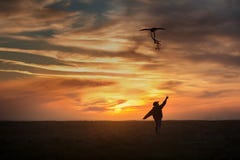 Piloter un cerf-volant Le gar?on court ? travers le champ avec un cerf-volant Coucher du soleil lumineux image stock Piloter un cerf-volant Le gar?on court ? travers le champ avec un cerf-volant Coucher du soleil lumineux image stock