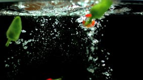 Pimientas de chile que caen en agua almacen de metraje de vídeo Pimientas de chile que caen en agua almacen de metraje de vídeo