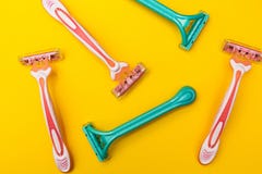 Pink and blue razors for women on a yellow background royalty free stock images Pink and blue razors for women on a yellow background royalty free stock images