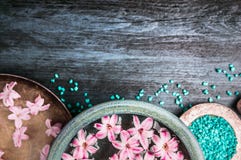 Pink flowers in bowls with water and blue sea salt on wooden table, wellness background, top view Stock Image Pink flowers in bowls with water and blue sea salt on wooden table, wellness background, top view Stock Image