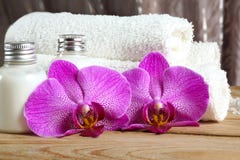 Pink orchid flowers near towels and white body lotion in the spa treatment room royalty free stock photos Pink orchid flowers near towels and white body lotion in the spa treatment room royalty free stock photos