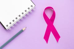 Pink ribbon and notepad on a purple background, the concept of female health, the fight against breast cancer royalty free stock photos Pink ribbon and notepad on a purple background, the concept of female health, the fight against breast cancer royalty free stock photos