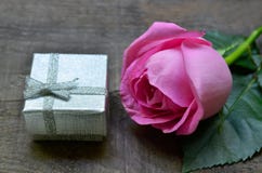 Pink rose and silver gift box on old wooden background. Mother´s Day,Women`s Day,Birthday greeting card concept. stock photo Pink rose and silver gift box on old wooden background. Mother´s Day,Women`s Day,Birthday greeting card concept. stock photo