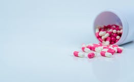 Pink-white capsule pills spread out of drug bottle. Antipsychotic drug. Capsule medicine for treatment depression. Anti-anxiety royalty free stock image Pink-white capsule pills spread out of drug bottle. Antipsychotic drug. Capsule medicine for treatment depression. Anti-anxiety royalty free stock image