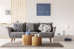 Pintura abstracta azul en la pared blanca de la sala de estar contemporánea interior con el canapé gris con las almohadas foto de archivo Pintura abstracta azul en la pared blanca de la sala de estar contemporánea interior con el canapé gris con las almohadas foto de archivo