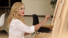 Pinturas bonitas del artista de la muchacha en la pintura de la lona en el caballete Arte almacen de video Pinturas bonitas del artista de la muchacha en la pintura de la lona en el caballete Arte almacen de video