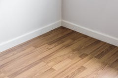 Piso de madera laminado con la pared blanca, esquina del ` s del sitio fotos de archivo libres de regalías Piso de madera laminado con la pared blanca, esquina del ` s del sitio fotos de archivo libres de regalías