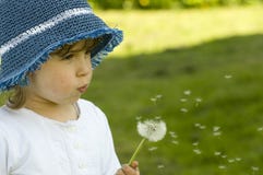 Pissenlit de soufflement de fille images stock Pissenlit de soufflement de fille images stock