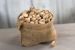 Pistacchi salati arrostiti nella borsa di tela da imballaggio Fotografia Stock Pistacchi salati arrostiti nella borsa di tela da imballaggio Fotografia Stock