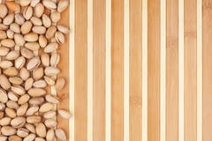 Pistachios Unpeeled que encontram-se em uma esteira de bambu Imagens de Stock Pistachios Unpeeled que encontram-se em uma esteira de bambu Imagens de Stock
