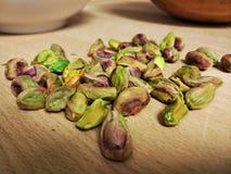 Pistacj dokrętki na drewnianym stole z drewnianym pucharem w tle i obraz stock Pistacj dokrętki na drewnianym stole z drewnianym pucharem w tle i obraz stock