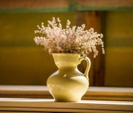 pitcher with wildflowers is standing on a wooden table in the room. stock photography pitcher with wildflowers is standing on a wooden table in the room. stock photography
