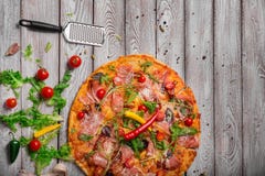 Pizza appena fatta con una scapola su una tavola Pizza su un fondo rustico Pizza con formaggio arrostito e pepe piccante fotografie stock Pizza appena fatta con una scapola su una tavola Pizza su un fondo rustico Pizza con formaggio arrostito e pepe piccante fotografie stock