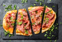 Pizza di Naan con il serrano del prosciutto sul bordo dell'ardesia fotografia stock libera da diritti Pizza di Naan con il serrano del prosciutto sul bordo dell'ardesia fotografia stock libera da diritti