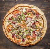 Pizza faite maison délicieuse avec la fin rustique en bois de vue supérieure de fond de tomates, de saucisse, d'oignon, de poulet photos libres de droits Pizza faite maison délicieuse avec la fin rustique en bois de vue supérieure de fond de tomates, de saucisse, d'oignon, de poulet photos libres de droits
