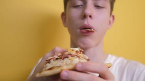 Pizza Gelukkige tienerjongen die een plak van pizzaconcept eet hongerige de tiener eet een plak van pizza langzame geanimeerde vi stock video Pizza Gelukkige tienerjongen die een plak van pizzaconcept eet hongerige de tiener eet een plak van pizza langzame geanimeerde vi stock video