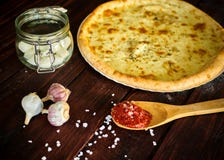 Pizza italiana deliciosa com queijo em uma tabela de madeira imagem de stock royalty free Pizza italiana deliciosa com queijo em uma tabela de madeira imagem de stock royalty free
