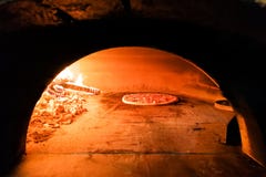 Pizza italienne étant faite cuire au four en four en bois traditionnel du feu de flamme Photos stock Pizza italienne étant faite cuire au four en four en bois traditionnel du feu de flamme Photos stock