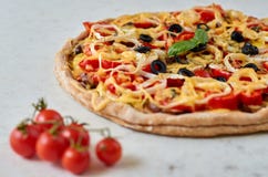 Pizza vegetariana caliente con los tomates, el paprika, la cebolla, las aceitunas negras, el queso y las especias en el cierre bl Foto de archivo libre de regalías Pizza vegetariana caliente con los tomates, el paprika, la cebolla, las aceitunas negras, el queso y las especias en el cierre bl Foto de archivo libre de regalías