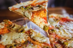 Pizza vegetariana su un fondo scuro con i funghi immagine stock libera da diritti Pizza vegetariana su un fondo scuro con i funghi immagine stock libera da diritti